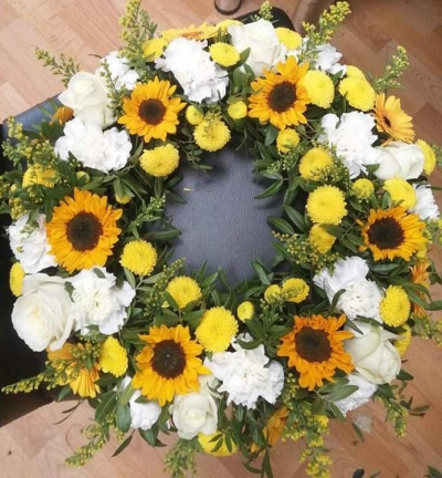 Sunshine Tribute Wreath - A bright funeral wreath in sunny yellow, warm golden and crisp white tones, finished with fresh greenery.
