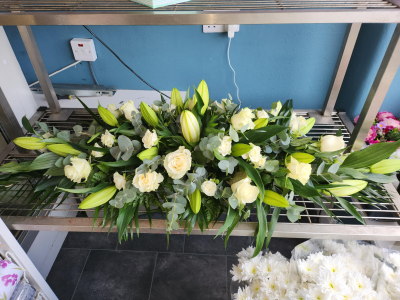 Coffin Spray - An elegant casket spray in soft white and fresh green tones, creating a graceful and peaceful tribute.